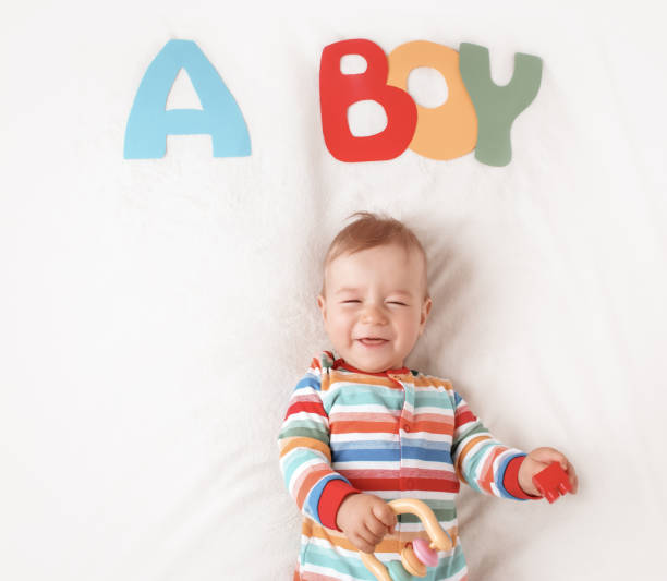 istock Baby boy lying on the blanket with letters above 1271581276