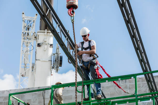 Construction worker removing chain from roof truss