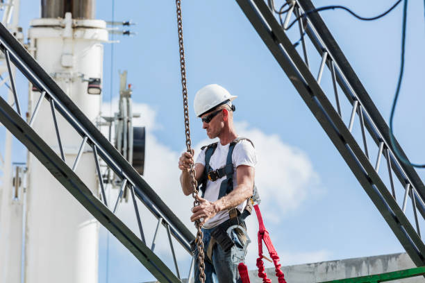 istock Construction worker attaching chain to roof truss 1271581556