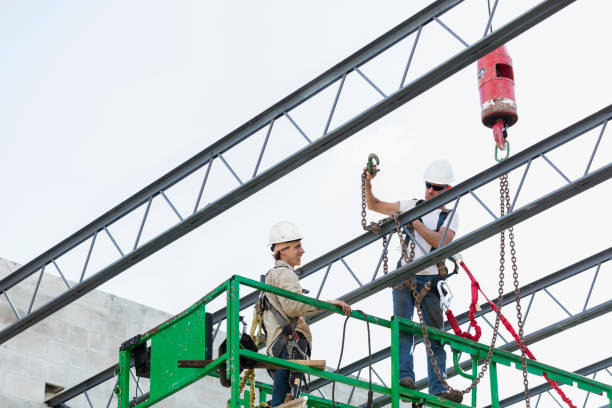 istock Steel workers installing roof trusses 1271581602