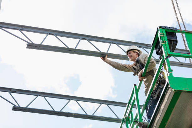 istock Construction worker on scissor lift moving roof joist 1271581612