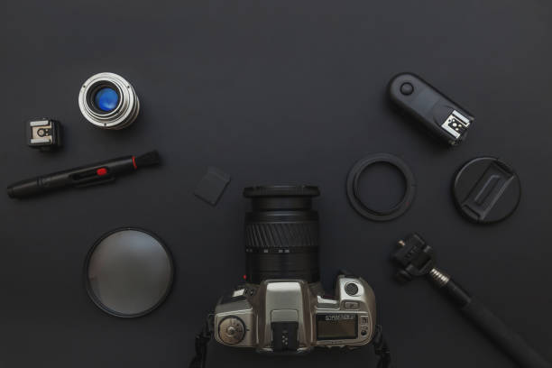 istock Photographer workplace with dslr camera system, camera cleaning kit, lens and camera accessory on dark black table background. Hobby travel photography concept. Flat lay top view copy space 1271581618