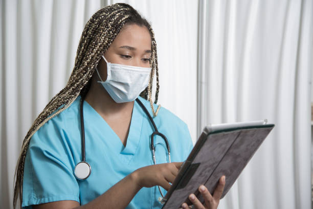istock African Descent nurse consults her schedule on digital tablet. 1271583830