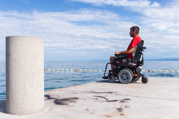 istock Man sitting in a wheelchair on the beach 1271588556