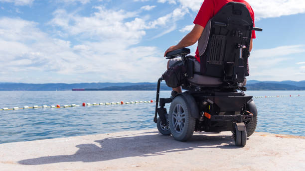 istock Man sitting in a wheelchair on the beach 1271588563