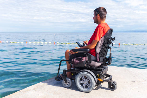 istock Man sitting in a wheelchair on the beach 1271588565