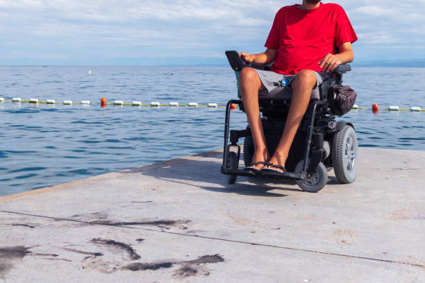 istock Man sitting in a wheelchair on the beach 1271588572