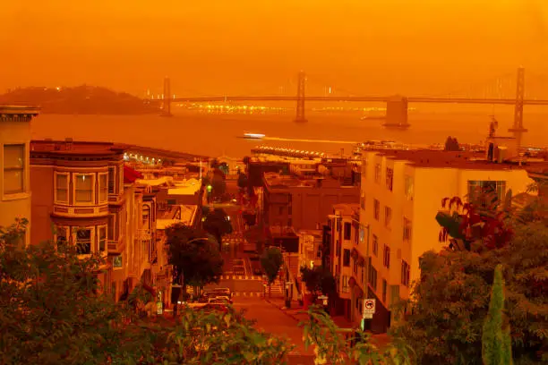 A View towards Bay Bridge as dark orange sky from the surrounding forest fires covers the city.
