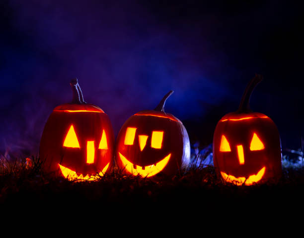 istock Halloween pumpkins over blue background with smoke. 1271593949