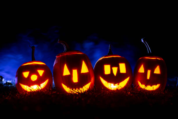 istock Iluminated horror pumpkins over blue background with smoke. 1271593987