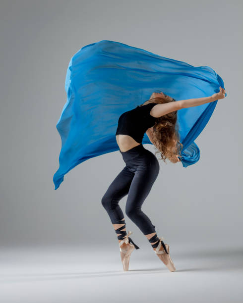 dancer with blue textile on the floor in motion