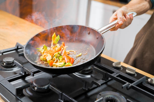 istock Chef cooking vegetables in pan 1271595038