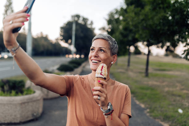 istock Beautiful woman vlogging while eating ice cream 1271598999