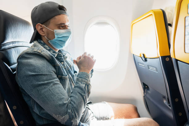 istock Man wearing prevention mask during a flight inside an airplane 1271605848