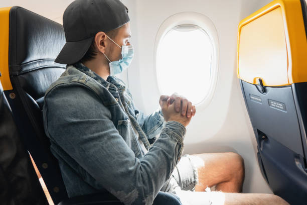 istock Man wearing prevention mask during a flight inside an airplane 1271605861