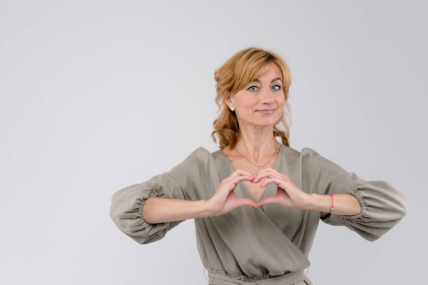 istock Smiling beautiful woman making heart shape with her hands isolated on white background 1271605899