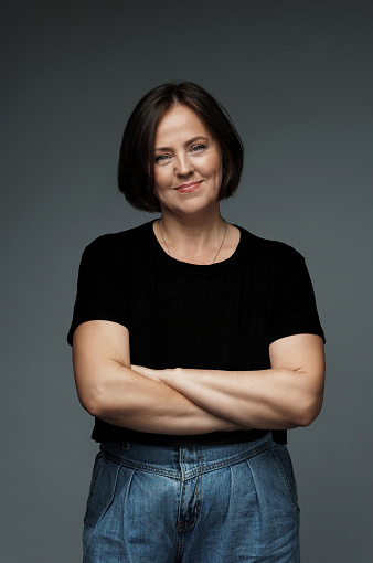 Positive middle aged woman wearing black t-shirt with empty space for your logo or text