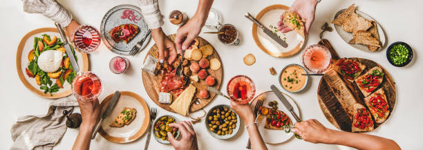 istock People eating and drinking rose wine over snacks and salads 1271606851