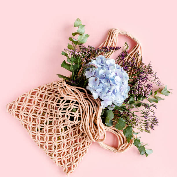 istock Beautiful bouquet of hydrangeas in a string, eco bag on white background. Flat lay, top view 1271606906
