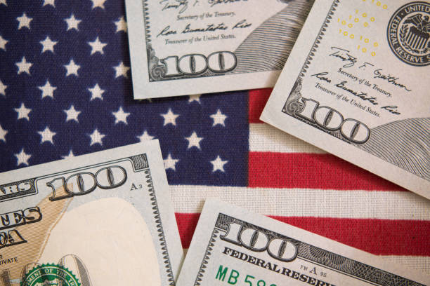 istock $100 dollar bills and American Flag. 1271607125