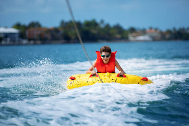 niño hispano siendo remolcado en tubo inflable - inner tube fotografías e imágenes de stock