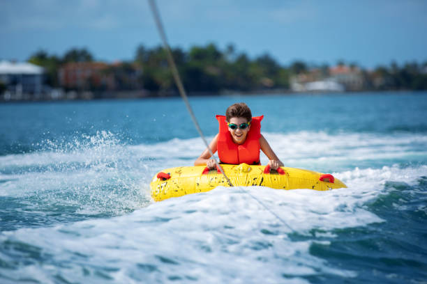 hispanic boy being towed on inflatable tube - swim ring imagens e fotografias de stock