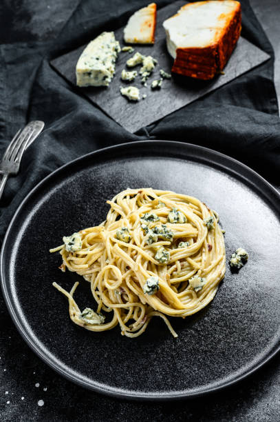 istock Spaghetti pasta with blue Gorgonzola cheese sauce. Black background. Top view. 1271608864