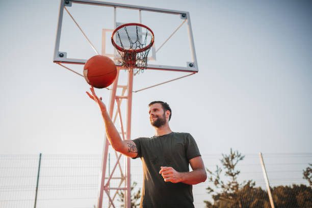 istock Handsome Young Man Spinning Basketball On Finger 1271609577