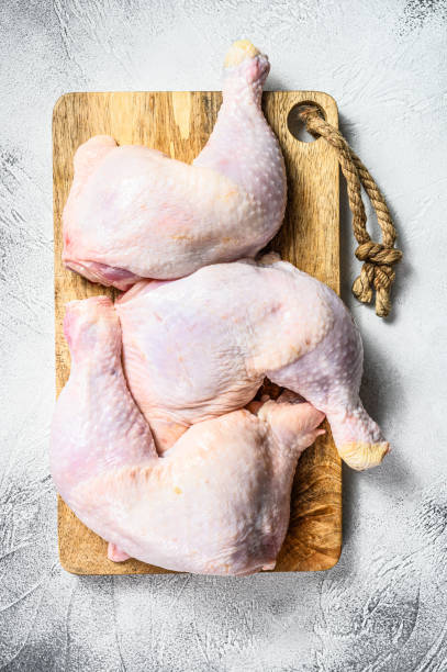 istock Fresh raw chicken thighs, legs on a chopping Board. Gray background. Top view. 1271609738