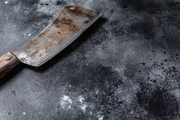 istock Meat cleaver on old scratched black  texture.  Dark background. Top view. Copy space 1271609761