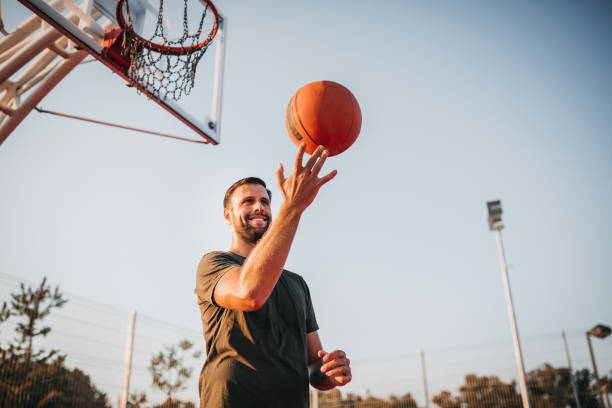 istock Handsome Young Man Spinning Basketball On Finger 1271610573