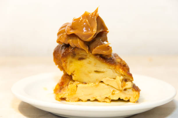 Piece of cake with honey shortcakes, cream boiled condensed milk and sprinkle with nuts on a white plate.
