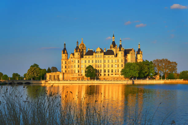 Schwerin Castle behind the reeds illuminated by natural sunlight. Schwerin, Germany - May 09, 2020: Schwerin Castle behind the reeds illuminated by natural sunlight. schwerin castle stock pictures, royalty-free photos & images