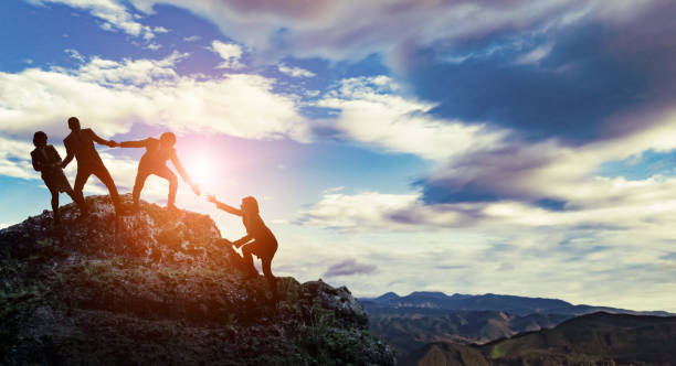 grupo de empresarios escalando una montaña. desafío del concepto de negocio. - helping fotografías e imágenes de stock