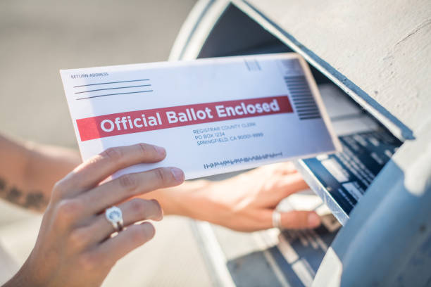 istock Woman Mailing Her Absentee Voter Ballot 1271621105
