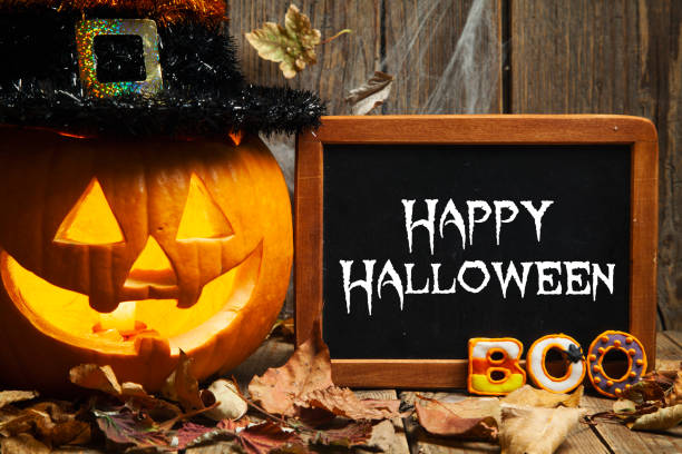 istock Halloween composition with chalkboard and gingerbread cookies on rustic wooden background 1271622684