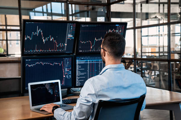Trader sitting in office, analyzing index on cryptocurrency diagram stock photo