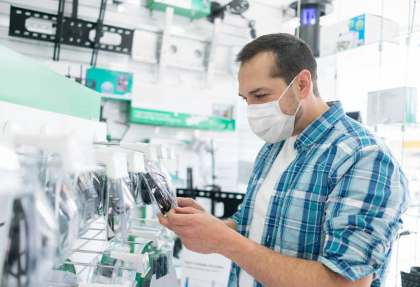 istock Man shopping for cables at an electronics store wearing a facemask 1271626556