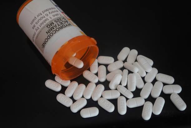 pílulas para dor opioide prescrita derramando fora do frasco de remédio - vicodin - fotografias e filmes do acervo