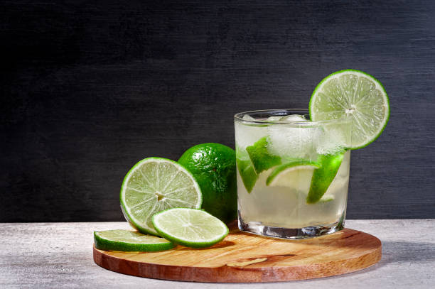 caipirinha brésilien sur une planche à découper avec le citron avec un fond de gradient, espace de copie - drink ice liquid mint photos et images de collection