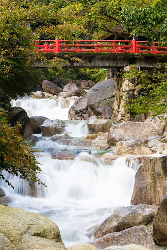 In the mountains of Mie prefecture, Japan there is a red bridge over a waterfall.