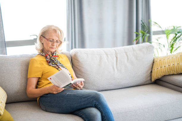 istock Mature woman reading a book at home. 1271638916