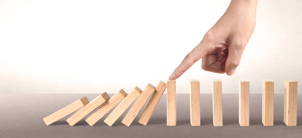 istock Domino wooden falling over effect stopped by unique 1271639016