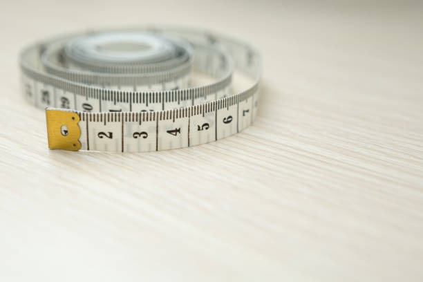 istock Tape measure on wood background and copy space 1271640002