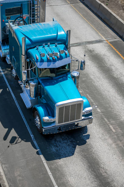 istock Powerful big rig classic stylish semi truck tractor with chrome accessories transporting frozen cargo in refrigerator semi trailer running on the road at sunny day 1271640702