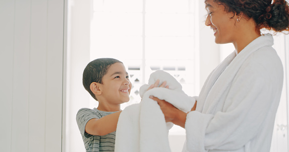 Cropped shot of a mother helping her adorable young son wipe his hands with a bathroom towel at home