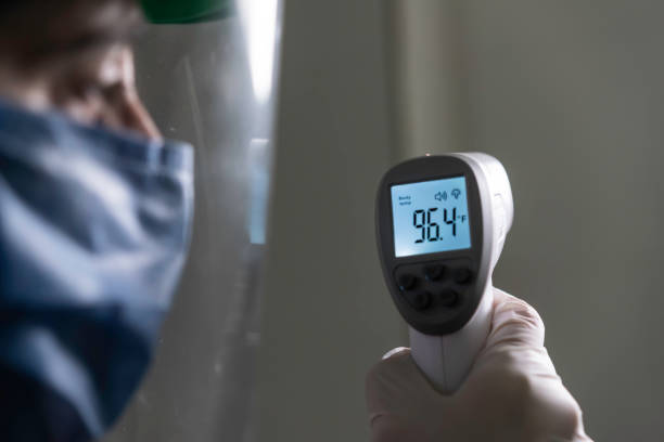 istock Middle age woman doctor taking temperature control- COVID concepts 1271643459