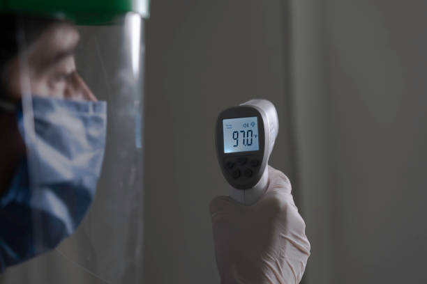 istock Middle age woman doctor taking temperature control- COVID concepts 1271643498