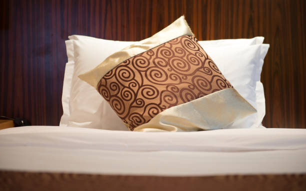 istock Fluffy pillows neatly placed on the hotel bed 1271649364