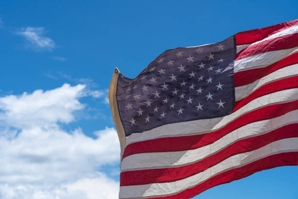 istock Waving USA flag under blue sky background. 1271650239